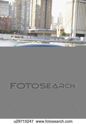 Stock Photo - Front View of Mid-Adult Woman Driving Smart Car. Fotosearch