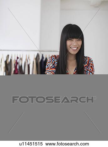 Stock Photography - Happy Sales Clerk in Clothing Store. Fotosearch