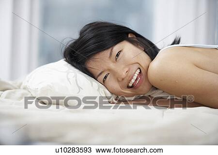 Stock Image - Happy Woman Lying in Bed. Fotosearch