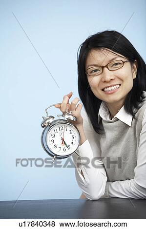 Mid-Adult Businesswoman Holding Alarm Clock View Large Photo Image Stock Photo - Mid-Adult Businesswoman Holding Alarm Clock. Fotosearch