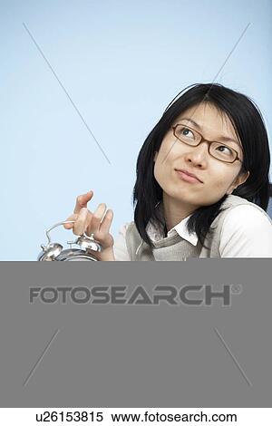 Stock Photography - Mid-Adult Businesswoman Holding Alarm Clock. Fotosearch