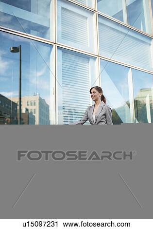 Stock Image - Mid-Adult Businesswoman Pulling Suitcase. Fotosearch