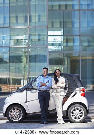 Stock Photo - Mid-Adult Couple by Smart Car. Fotosearch