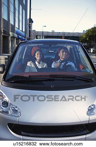 Stock Image - Mid-Adult Couple Driving Smart Car. Fotosearch