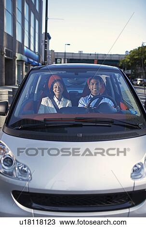 Stock Image - Mid-Adult Couple Driving Smart Car. Fotosearch