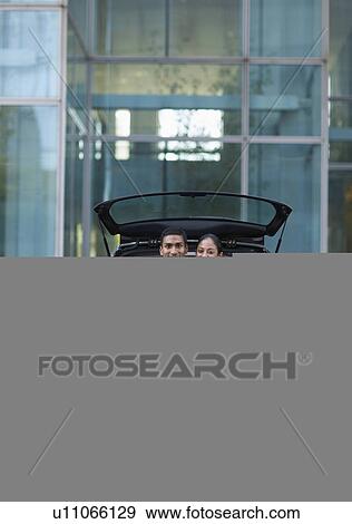 Stock Photo - Mid-Adult Couple Sitting in Car Trunk. Fotosearch