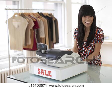 Stock Image - Mid Adult Sales Clerk in Clothes Store. Fotosearch