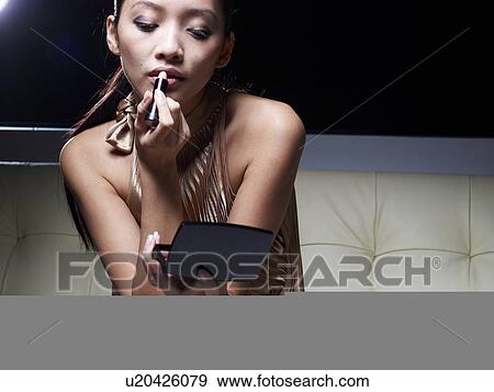 Stock Photo - Mid-Adult Woman Applying Lipstick. Fotosearch