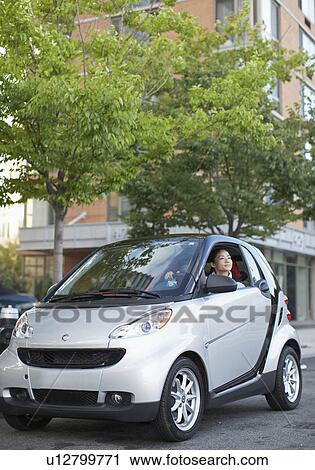 Stock Image - Mid-Adult Woman Driving Smart Car. Fotosearch