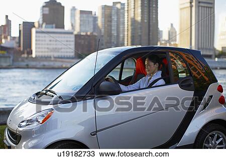 Stock Image - Mid-Adult Woman Driving Smart Car. Fotosearch
