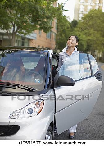 Stock Photo - Mid-Adult Woman Getting Into Smart Car. Fotosearch