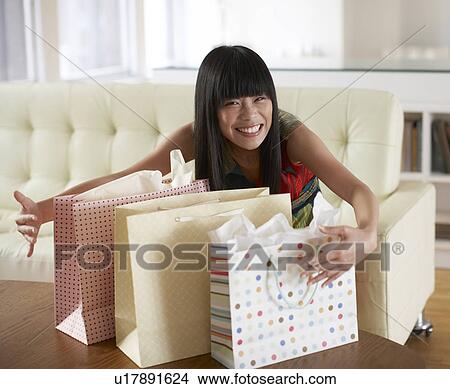 Picture - Mid Adult Woman Grabbing Shopping Bags. Fotosearch