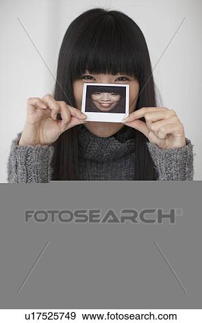 Mid-Adult Woman Holding Photograph of Herself View Large Photo Image Stock Photo - Mid-Adult Woman Holding Photograph of Herself. Fotosearch