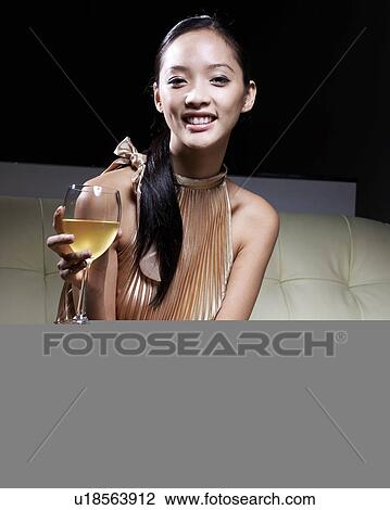 Stock Image - Mid-Adult Woman in Evening Dress Drinking White Wine . Fotosearch