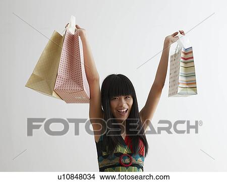 Picture - Mid Adult Woman Lifting Shopping Bags. Fotosearch