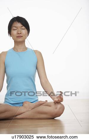 Stock Photography - Mid Adult Woman Meditating in Lotus Position. Fotosearch
