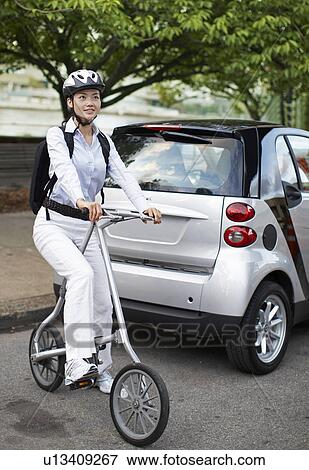 Mid-Adult Woman on Bicycle Beside Smart Car View Large Photo Image Stock Photo - Mid-Adult Woman on Bicycle Beside Smart Car. Fotosearch