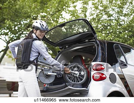 Mid-Adult Woman Putting Bicycle into Car Trunk View Large Photo Image Stock Photography - Mid-Adult Woman Putting Bicycle into Car Trunk. Fotosearch