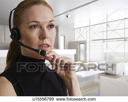 Stock Photo - Mid-Adult Woman Talking Through Headset. Fotosearch
