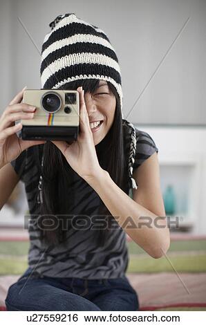 Stock Photograph - Mid Adult Woman Using Instant Camera. Fotosearch
