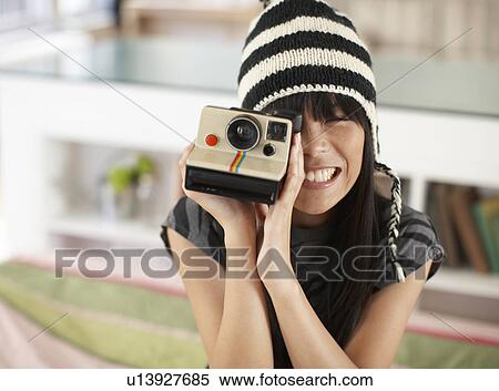 Stock Photography - Mid Adult Woman Using Instant Camera. Fotosearch