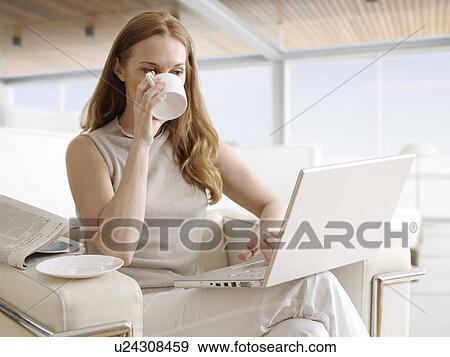 Mid-Adult Woman Using Laptop and Having Coffee View Large Photo Image Stock Photo - Mid-Adult Woman Using Laptop and Having Coffee. Fotosearch