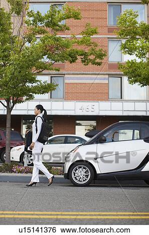 Stock Photograph - Mid-Adult Woman Walking Near Smart Car. Fotosearch