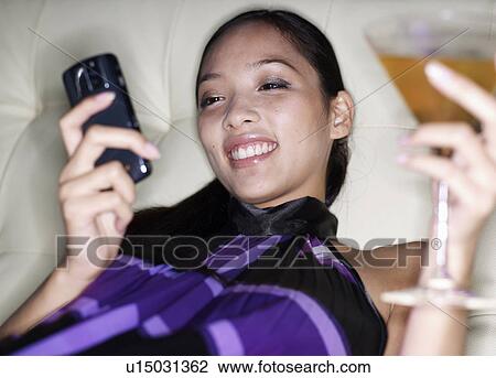 Mid-Adult Woman with Cocktail Using Cell Phone View Large Photo Image Stock Image - Mid-Adult Woman with Cocktail Using Cell Phone. Fotosearch