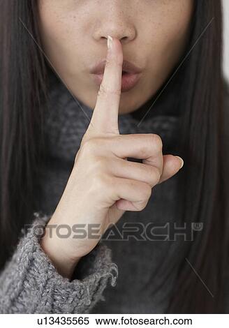 Stock Photography - Mid-Adult Woman With Finger Over Lips. Fotosearch
