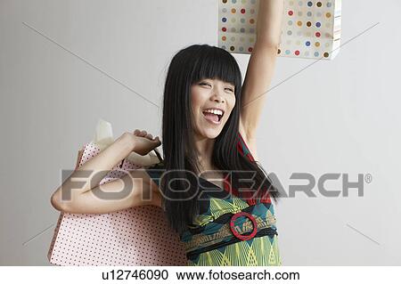 Stock Image - Mid Adult Woman with Opening Shopping Bags. Fotosearch