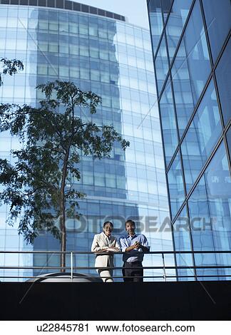 Stock Image - Portrait of Two Businesspeople on Foot Bridge. Fotosearch