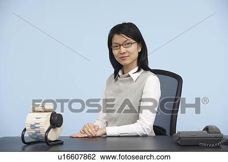 Smart Mid-Adult Woman Sitting at Desk View Large Photo Image Stock Image - Smart Mid-Adult Woman Sitting at Desk. Fotosearch