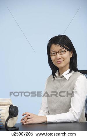 Smart Mid-Adult Woman Sitting at Desk View Large Photo Image Stock Photography - Smart Mid-Adult Woman Sitting at Desk. Fotosearch