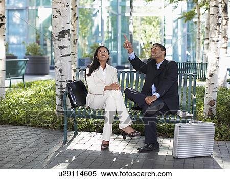 Stock Photography - Two Businesspeople Looking Up in Park. Fotosearch