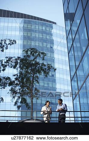 Stock Image - Two Businesspeople Talking on Footbridge. Fotosearch