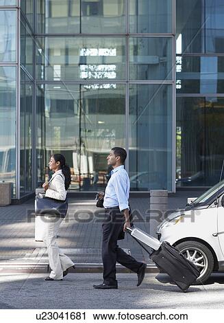 Two Businesspeople Walking with Suitcase View Large Photo Image Stock Image - Two Businesspeople Walking with Suitcase. Fotosearch