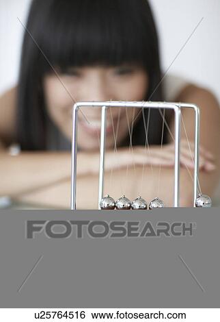 Woman Looking at Newton's Cradle View Large Photo Image Stock Photograph - Woman Looking at Newton's Cradle. Fotosearch