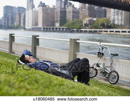 Young Man Listening to Headphones at Waterfront View Large Photo Image Stock Photography - Young Man Listening to Headphones at Waterfront. Fotosearch