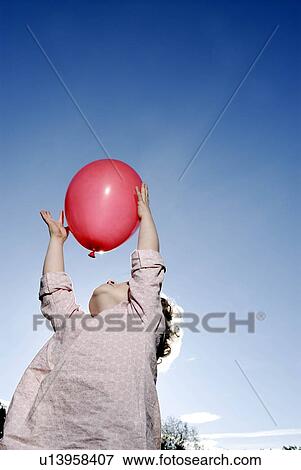 Stock Photo - 3 years old girl holding a balloon. Fotosearch