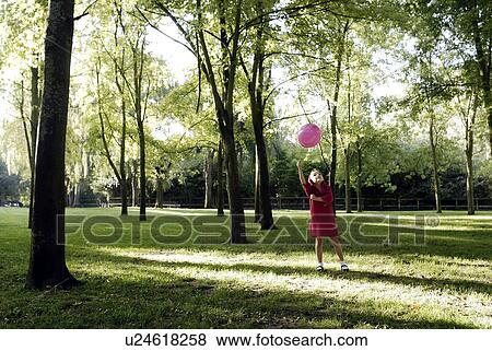 Stock Photo - 5 years old girl holding a balloon. Fotosearch