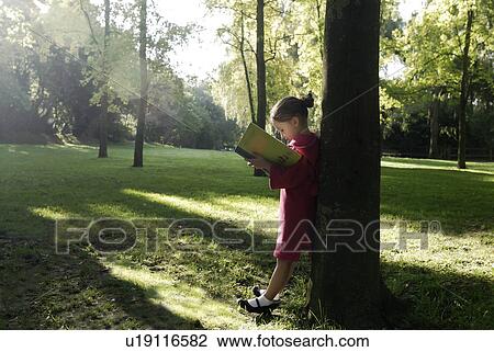 Stock Image - 5 years old girl holding a book. Fotosearch