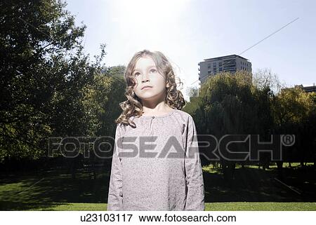 Stock Photo - 5 years old girl looking at the sky. Fotosearch