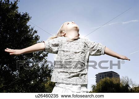 Stock Photography - 5 years old girl looking at the sky. Fotosearch