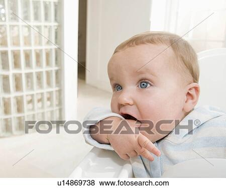 A baby boy sitting in his high chair. View Large Photo Image Stock Photo - A baby boy sitting in his high chair.. Fotosearch