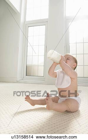 Picture - A baby drinking from a milk bottle.. Fotosearch