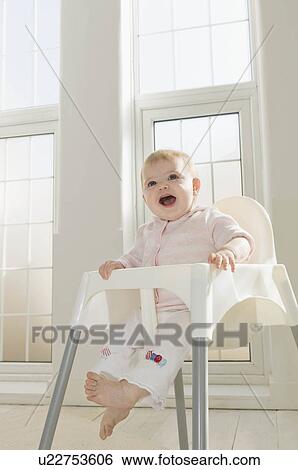 A baby girl in a high chair View Large Photo Image Stock Photograph - A baby girl in a high chair. Fotosearch