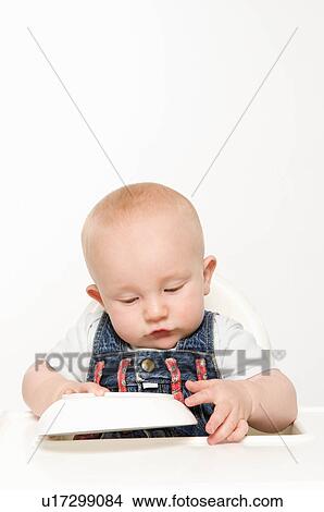 Picture - A baby playing with his food bowl. Fotosearch