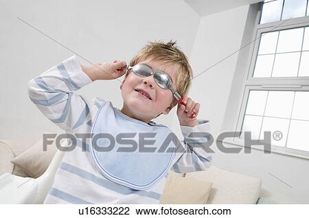 A boy holding spoons over his eyes View Large Photo Image Stock Image - A boy holding spoons over his eyes. Fotosearch
