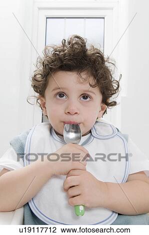 A boy sucking a spoon. View Large Photo Image Stock Image - A boy sucking a spoon.. Fotosearch