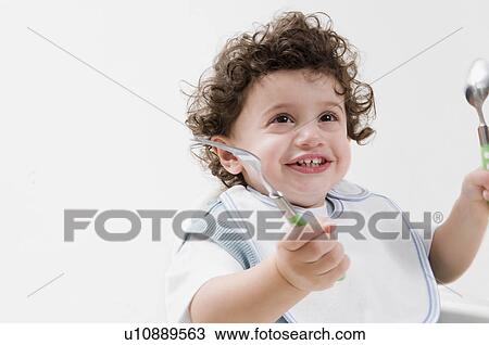 Stock Image - A boy waiting for his food smiling.. Fotosearch